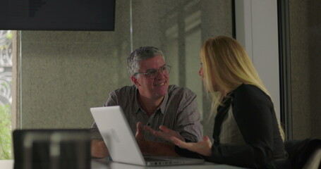 Colleagues smile and clasp hands in moment of friendly support during office meeting, celebrating teamwork and shared success
