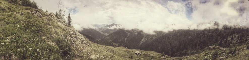 Panoramic view of a foggy mountain valley with lush greenery