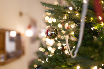 Snowy blue Christmas background with fir branches, ornaments, and shimmering lights, creating a...