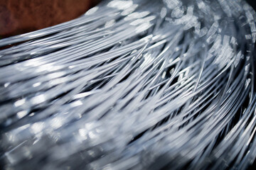 Detailed close-up of steel wires bundled together in an industrial setting. The image emphasizes...