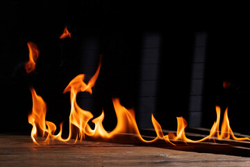 Bonfire flames burning on the floor or wooden table on black background.