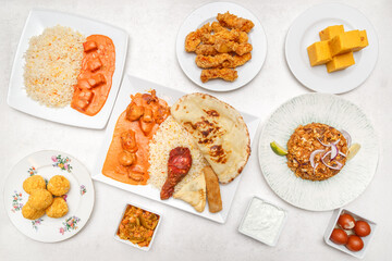 Ensemble de plats indiens et sri-lankais – Roti, Kottu, Tandoori, Butter Chicken, Rolls, Biryani sur table blanche. Concept restaurant. 