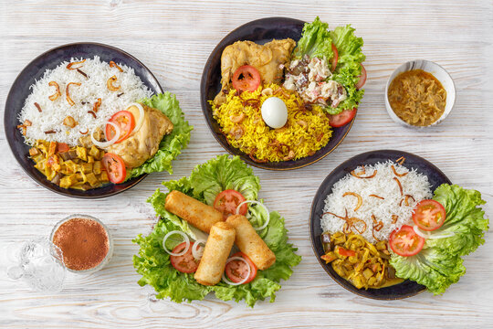 Vari&eacute;t&eacute; de plats indiens et sri-lankais &ndash; Roti, Kottu, Tandoori, Butter Chicken, Rolls, Biryani sur table blanche. Concept restaurant. 