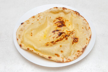 Naan au fromage sur fond blanc – pain indien traditionnel