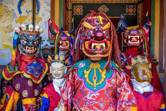 Jakar, Bhutan - 24 September 2025: View of vibrant dancers adorned in elaborate masks and costumes, embodying ancient spirits against the backdrop of a traditional Bhutanese building.