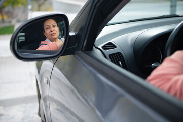 Woman Driver Looks Into Side Mirror Inside Car, Calm Moment of Travel and Reflection