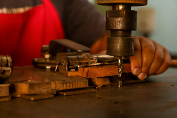 Violin making by hand bow. Close-up of an artisan&rsquo;s hands sanding or shaping a tool handle on a workbench. 