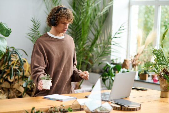Creative man engaged in a virtual meeting in a greenery filled workspace - Powered by Adobe