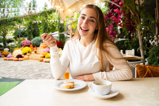 Happy young woman enjoying cottage cheese pancakes and coffee at cafe table in natural light, lifestyle portrait of woman having sweet breakfast outdoors
- Powered by Adobe