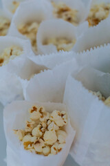 Several paper cones filled with popcorn arranged together. The image shows a snack setup suitable for parties, events, or food service.
