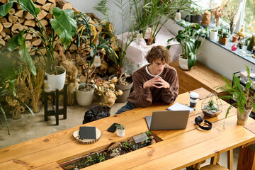 Creative young man brainstorming ideas in a modern eco friendly workspace