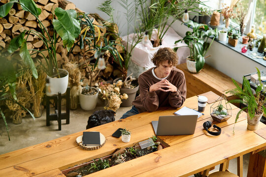 Creative young man brainstorming ideas in a modern eco friendly workspace