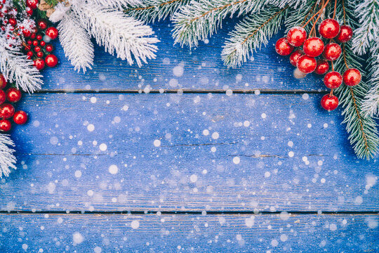 Festive christmas border with snow on rustic blue wooden background