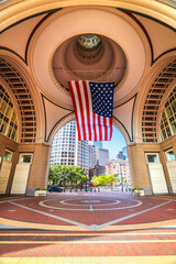 Boston harbor Rowes Wharf passage and cityscape view, large flag of America
