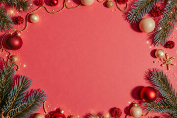 Obraz premium Festive christmas ornaments and pine branches frame a pink background