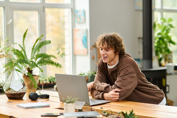 Creative young man engaged in innovative projects in a bright and plant filled workspace