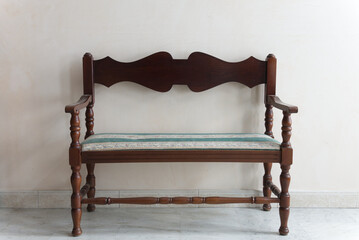 Rustic wooden bench with an embroidered cushion in a refined interior with marble floors and...