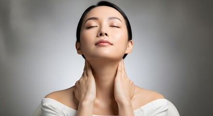 Asian woman with closed eyes, her hands gently touching her neck, a moment of inner peace and tranquility.