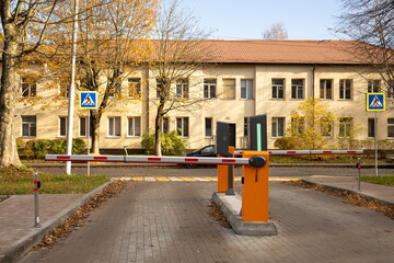 Automatic entry barrier with control terminal on residential driveway near pedestrian crossing