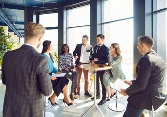 Young diverse people group of company employees talking on business meeting sitting in modern office during a conference, discussing new job projects or startups. Teamwork concept.