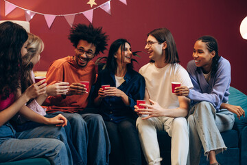 Diverse young adults having fun at a social gathering, enjoying a relaxed party