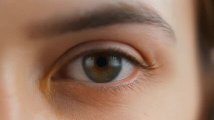 Close-up of a human eye opening, showing intricate details and captivating expression