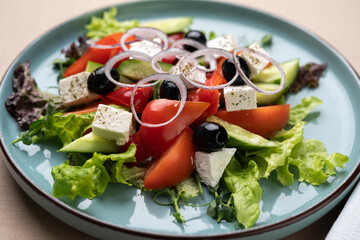 Fresh Greek Salad with Feta Cheese on plate on restaurant. Healthy Food
