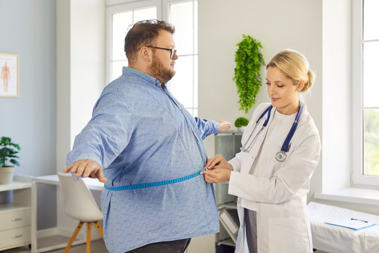 Doctor measures patient waist with tape, assessing obesity. Healthcare professional checks waist size, tracking progress and guiding diet and exercise. Theme: weight management monitoring.