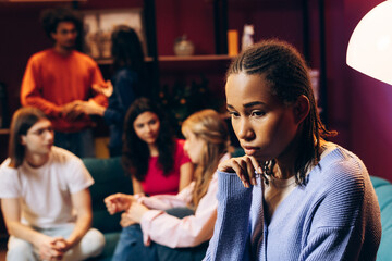 Young woman feeling isolated and lonely at a social gathering or party