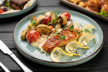 grilled salmon fish pieces with bbq vegetables and mushrooms on plate.