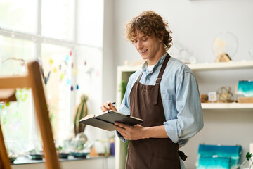 Creative young man capturing ideas in a cozy studio surrounded by art