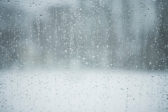 Raindrops on window  on snowy winter day