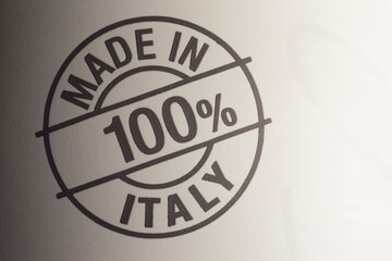 100% made in Italy stamp logo on beige background