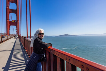 Portrait of smiling woman standing on Golden Gate Bridge on sunny day