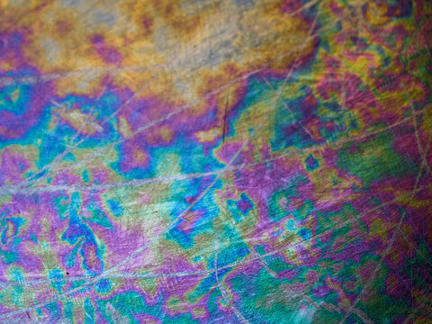 Close-up view of scratched and oxidized stainless steel pan