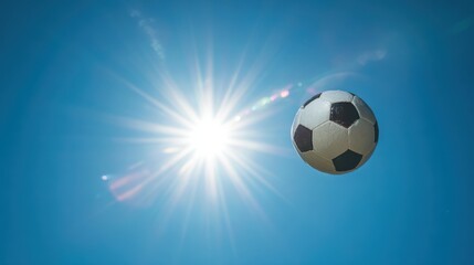 Soccer ball soaring in the air against bright blue sky