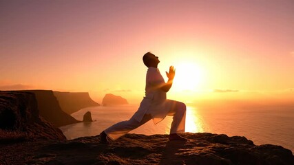 silhouette of person in warrior yoga pose on mountain cliff at sunset. scenic ocean view. concept of wellness, balance, spirituality, and mindfulness. - Powered by Adobe