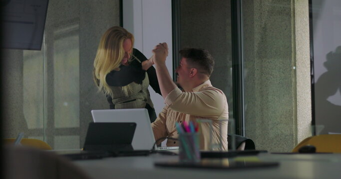 Coworkers celebrate success with cheerful high five in front of laptop during office meeting, smiling and standing together in modern workplace