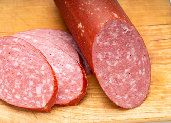 Close-up of sliced ​​smoked sausage on a kitchen board