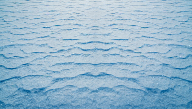 Abstract texture of undulating snow surface showcasing intricate natural patterns formed by wind and cold weather conditions, creating a serene winter backdrop with subtle blue hues