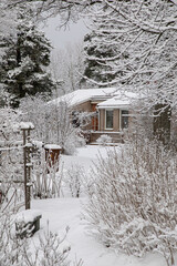 A private stone house surrounded by snow-covered trees on a winter day