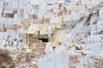 Marble quarry working machines of Carrara, Italy. Stoneworking industry. Natural resource exploitation.