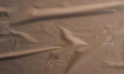 Folded white paper texture backdrop, crumpled poster surface, empty background for text or graphics