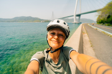 shikoku, japan - 3 august 2025 Female cyclist on Shimanami kaido cycling route