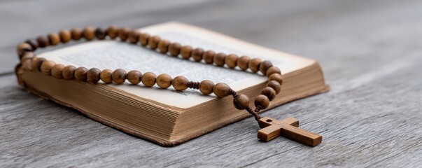 Wooden rosary beads with cross on antique bible for religious devotion and study