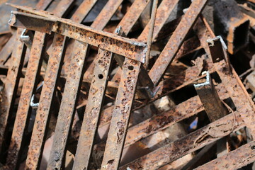 Close-up of weathered, rusted metal bars and beams in a scrap yard