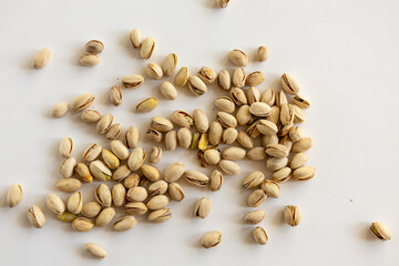 Scattered pistachio nuts on white background