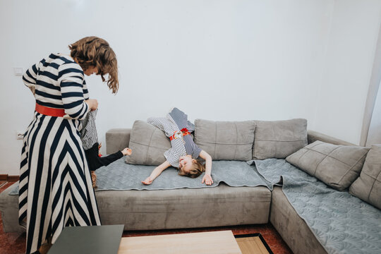 A family enjoying playful and joyful moments together in a comfortable living room setting. The image portrays happiness and bonding among family members.