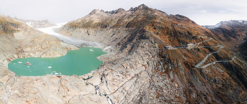 The melting Rh&ocirc;ne Glacier feeds a large turquoise lake beside the winding Furka Pass road and iconic Hotel Belv&eacute;d&egrave;re.