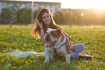 Young brunette girl play with her british bulldog